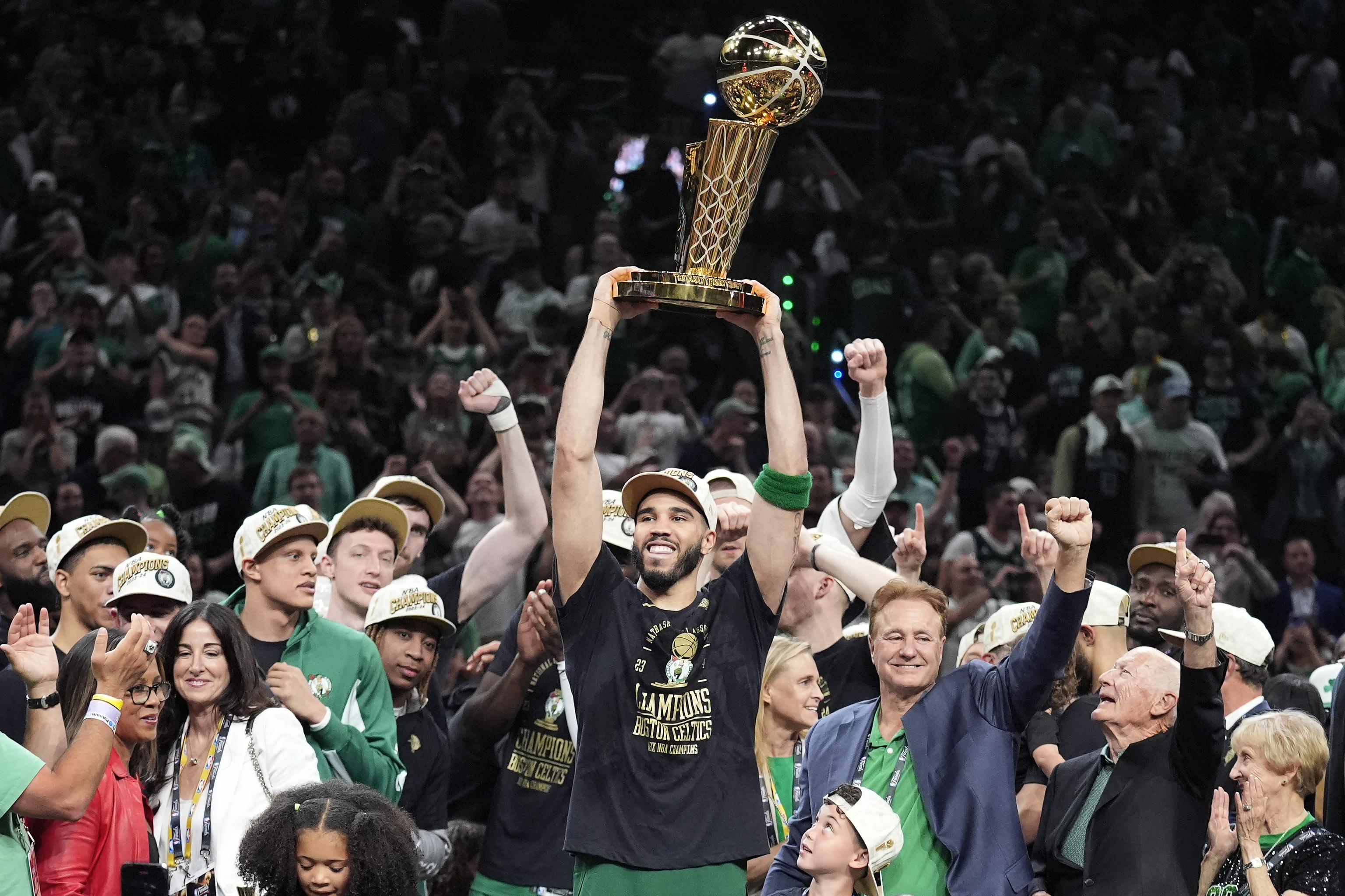 El jugador de los Celtics Jayson Tatum levanta el trofeo de campeones de la NBA.