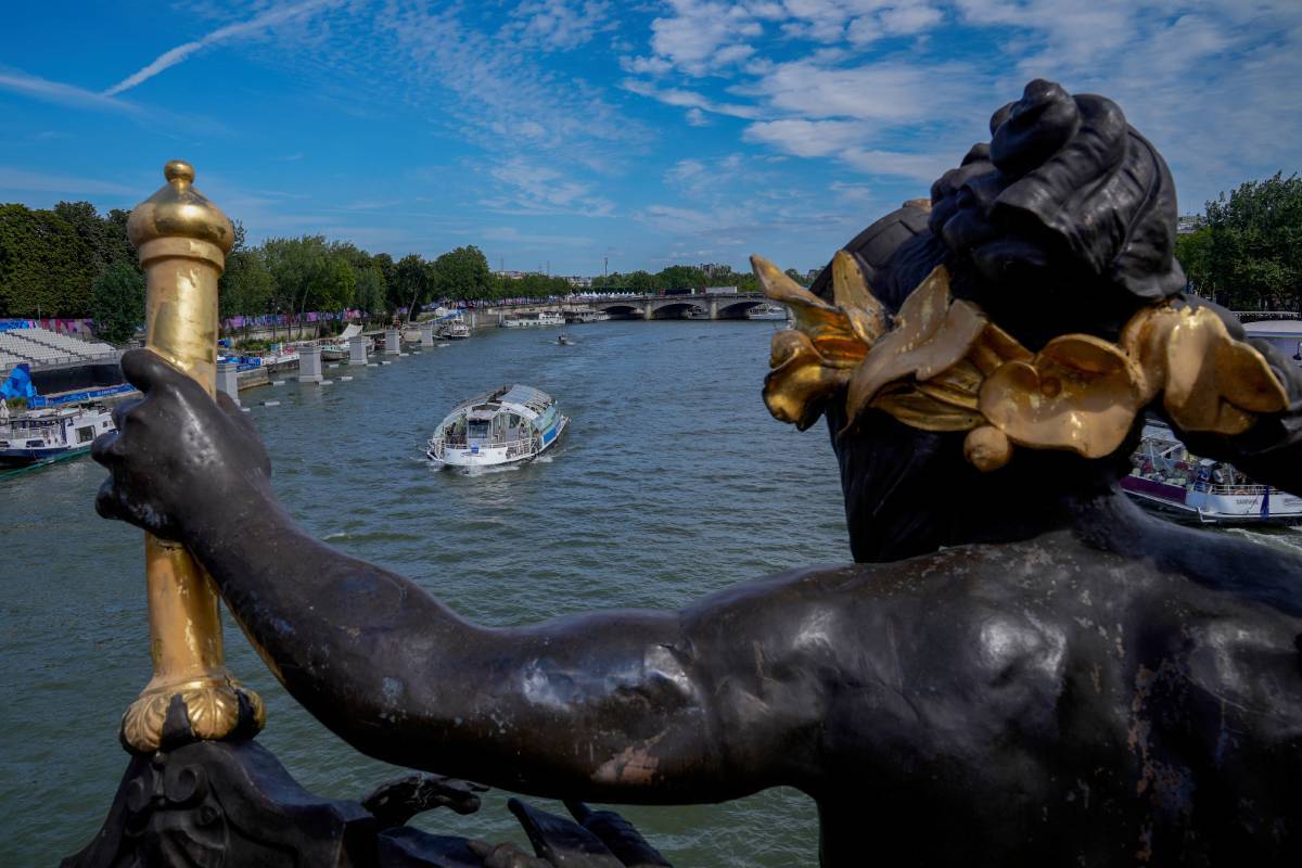 Una barcaza surca por el río Sena frente al puente Alexandre III durante los Juegos Olímpicos de París