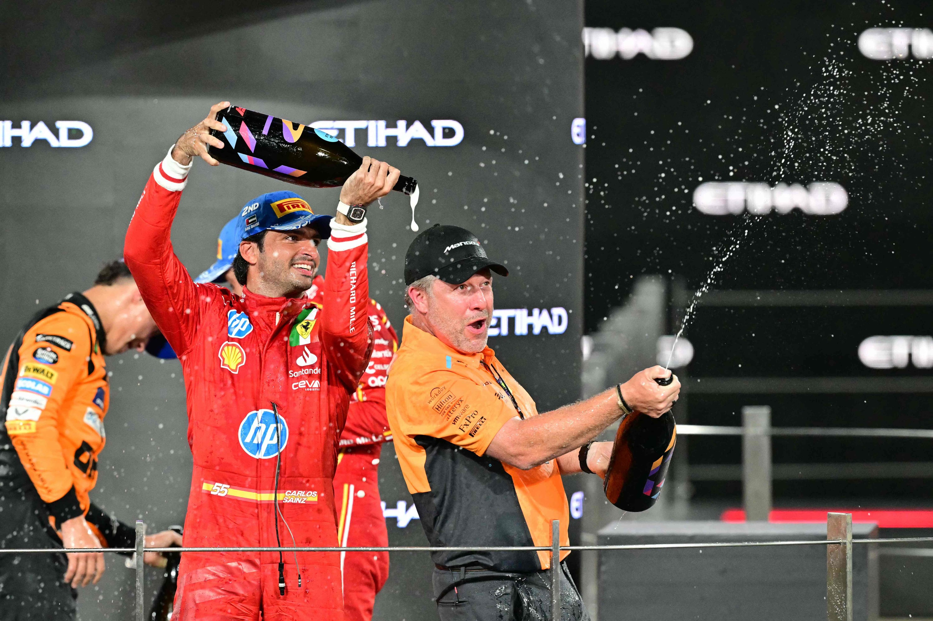 Sainz baña con champán a Zak Brown, el domingo en Yas Marina.