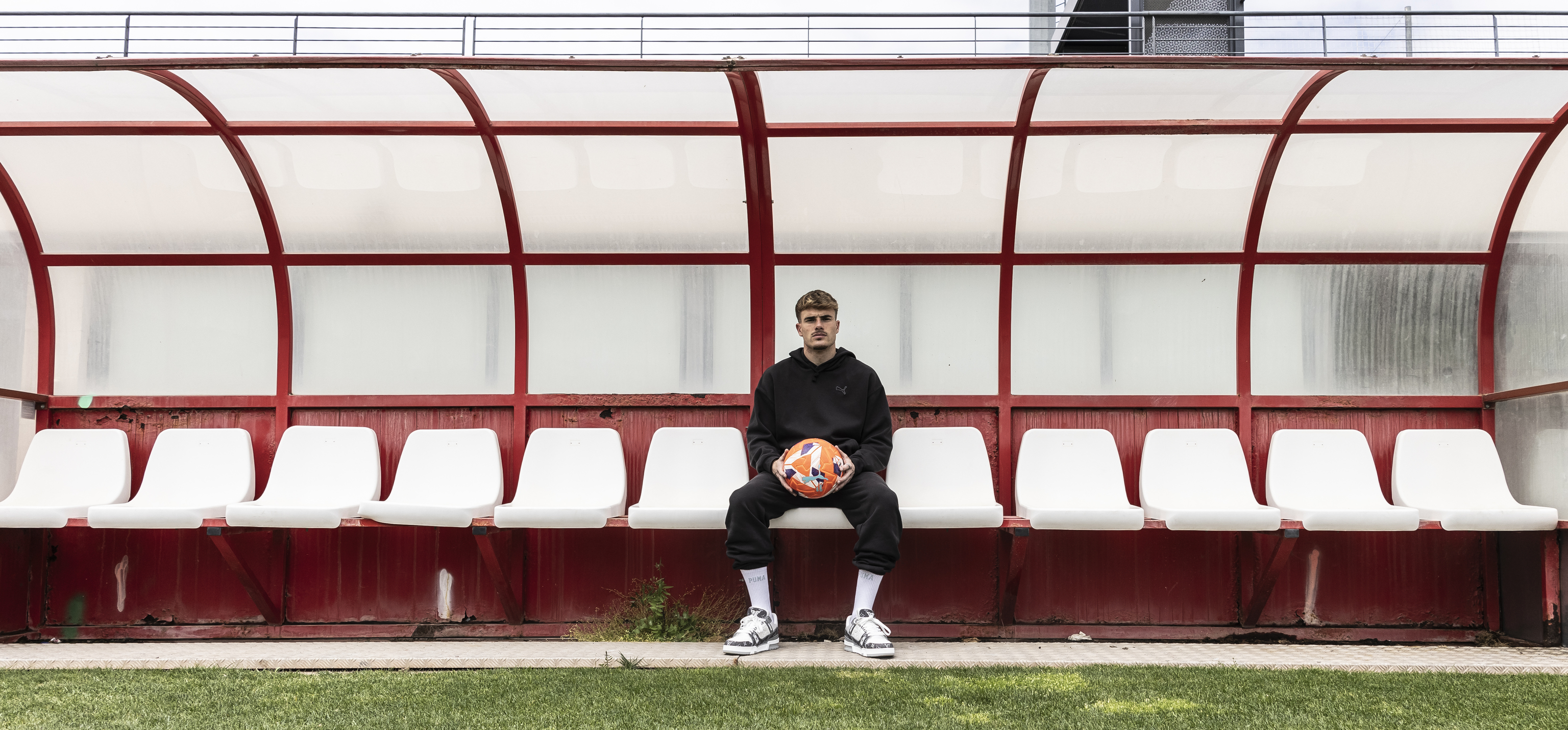 El jugador sostiene un balón en el banquillo.