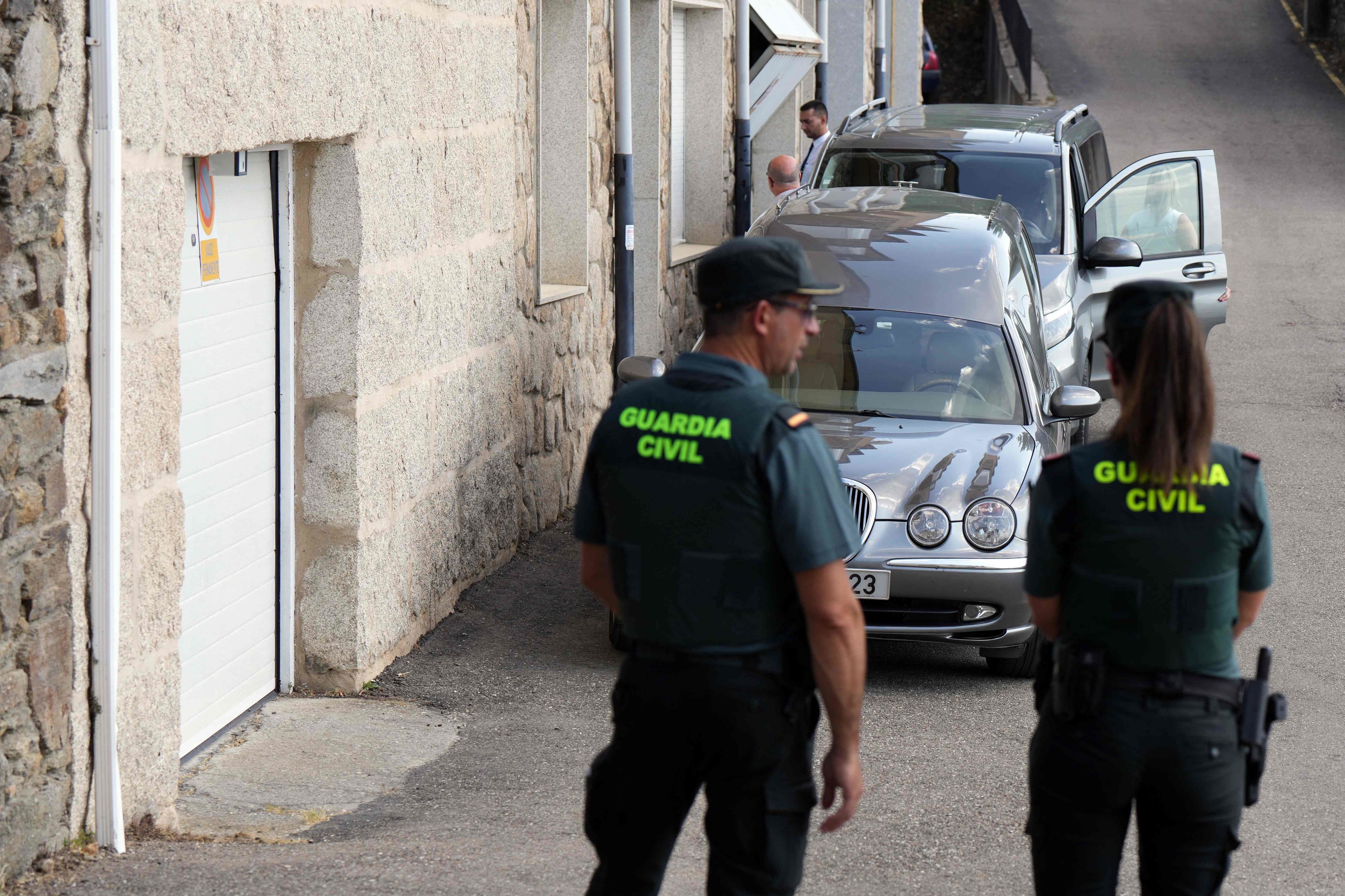 Una pareja de la Guardia Civil, frente a los coches con los féretros de Diogo Jota y su hermano.