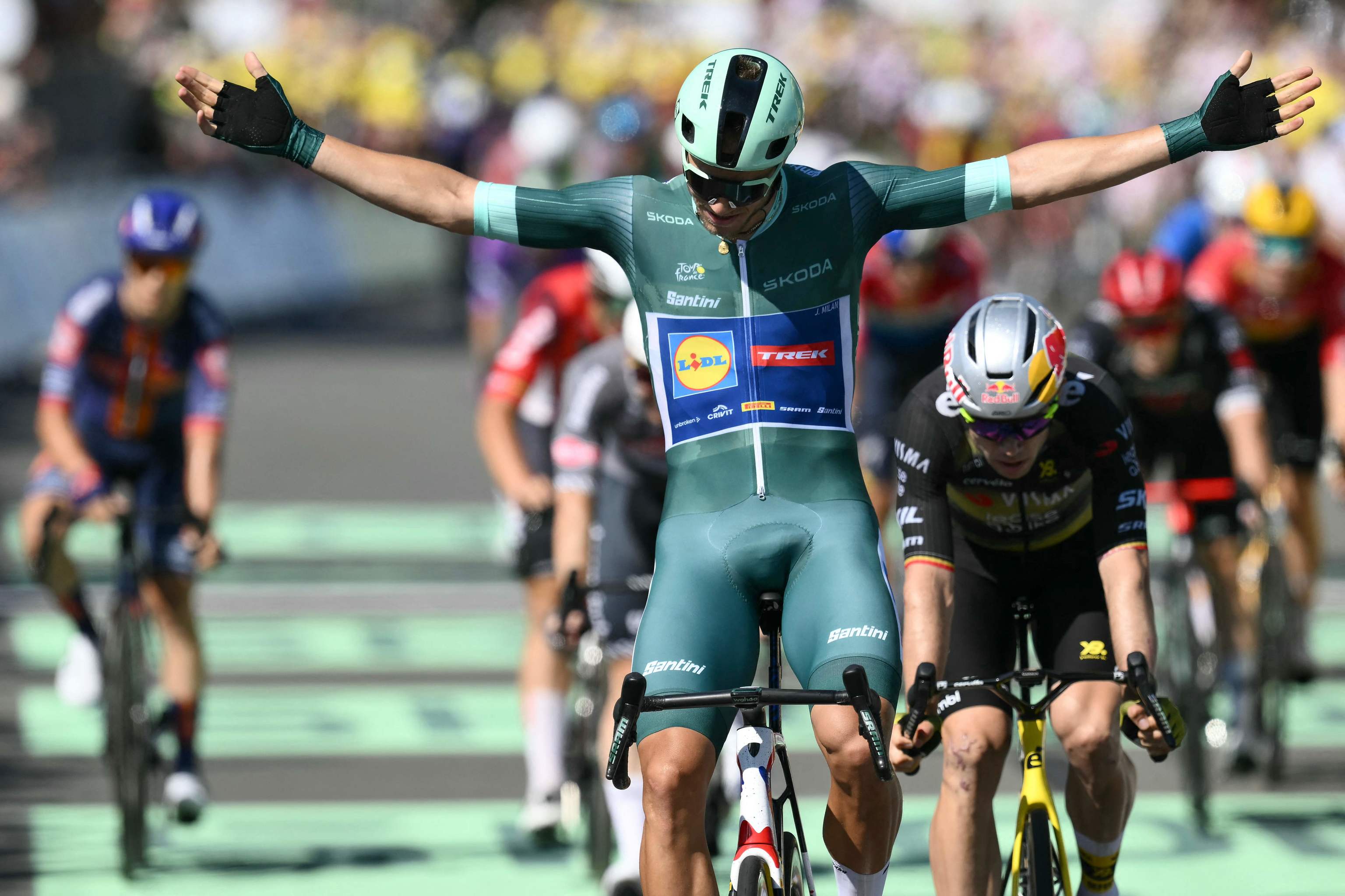 Jonathan Milan celebra su victoria en Laval, por delante de Van Aert.