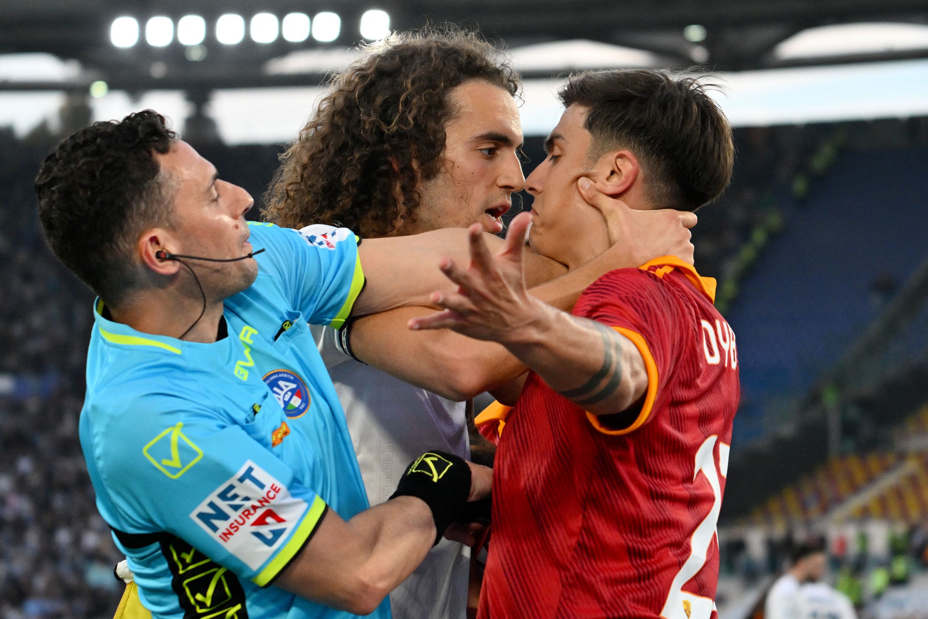 TOPSHOT - El delantero argentino #21 de Roma, Paulo Dybala (der.), discute con el mediocampista francés #08 de Lazio, Matteo Guendouzi, durante el partido de fútbol de la Serie A italiana entre AS Roma y Lazio el 6 de abril de 2024 en el estadio Olímpico de Roma. (Foto de Alberto PIZZOLI / AFP)