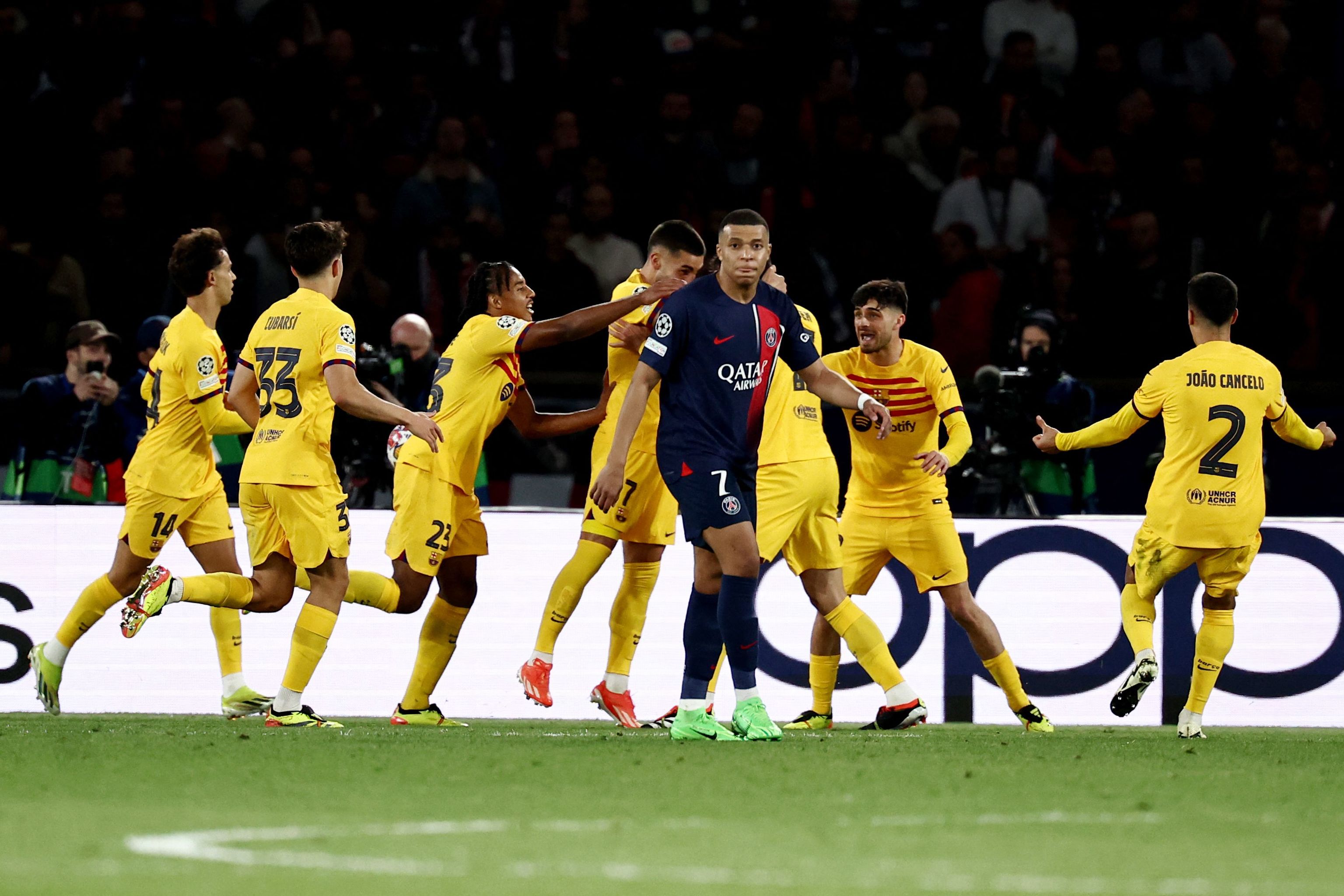Los futbolistas del Barça celebran un gol ante Mbappé.