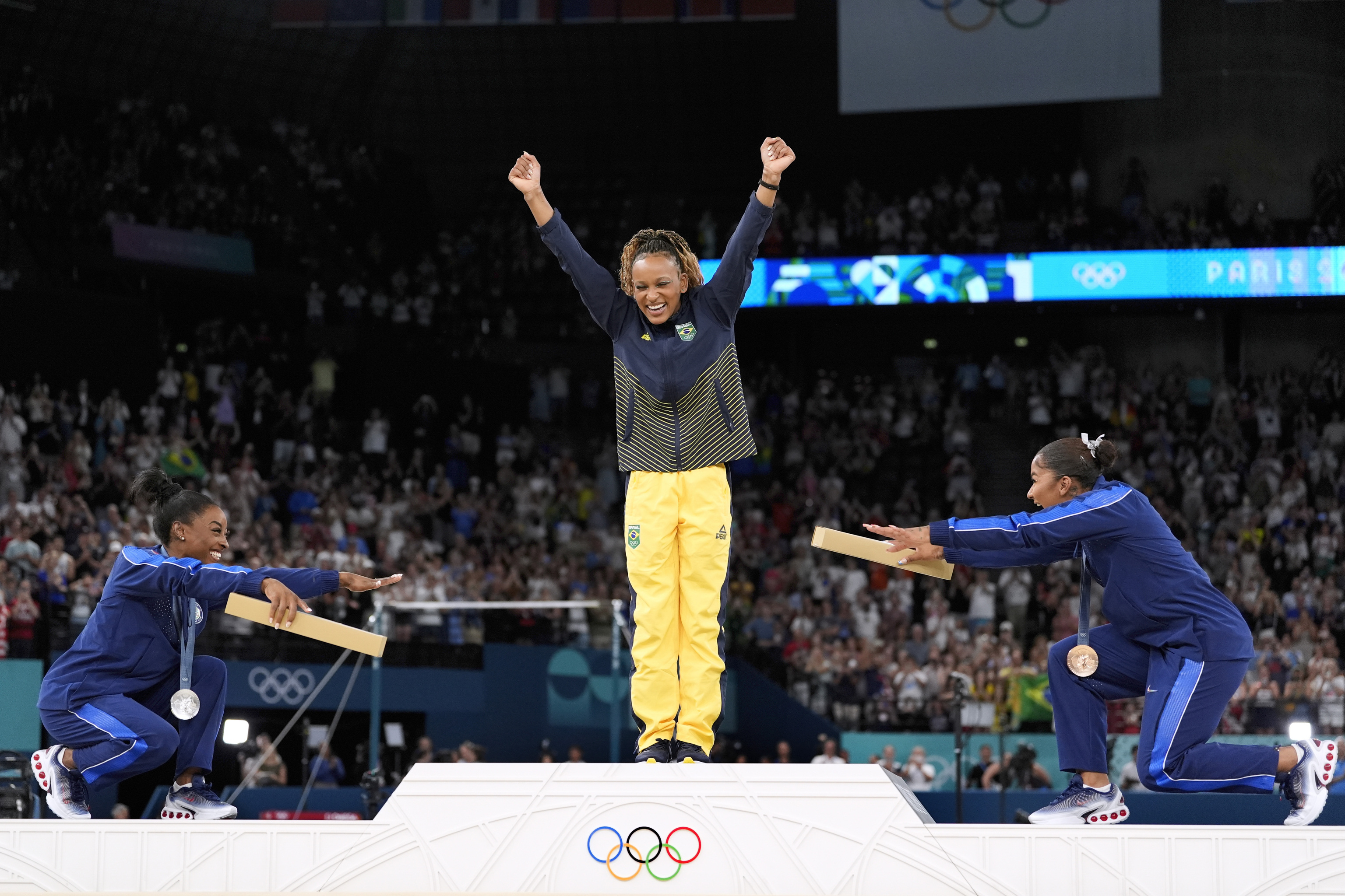 Biles y Jordan Chiles reverencian a la brasileña Rebeca Andrade en el podio de Bercy.