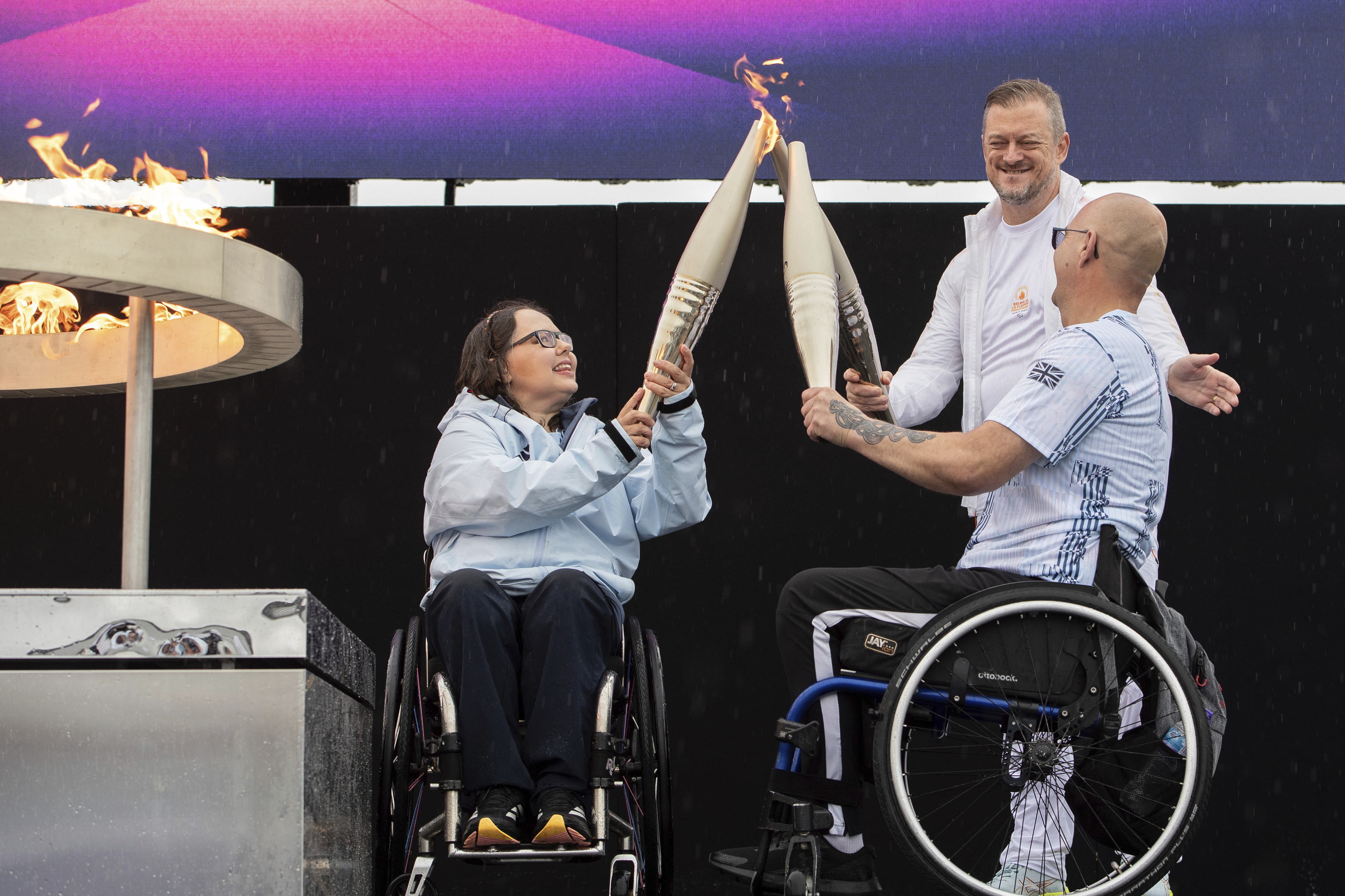 Los atletas paralímpicos británicos Helene Raynsford y Gregor Ewan encienden la llama paralímpica en Stoke Mandeville