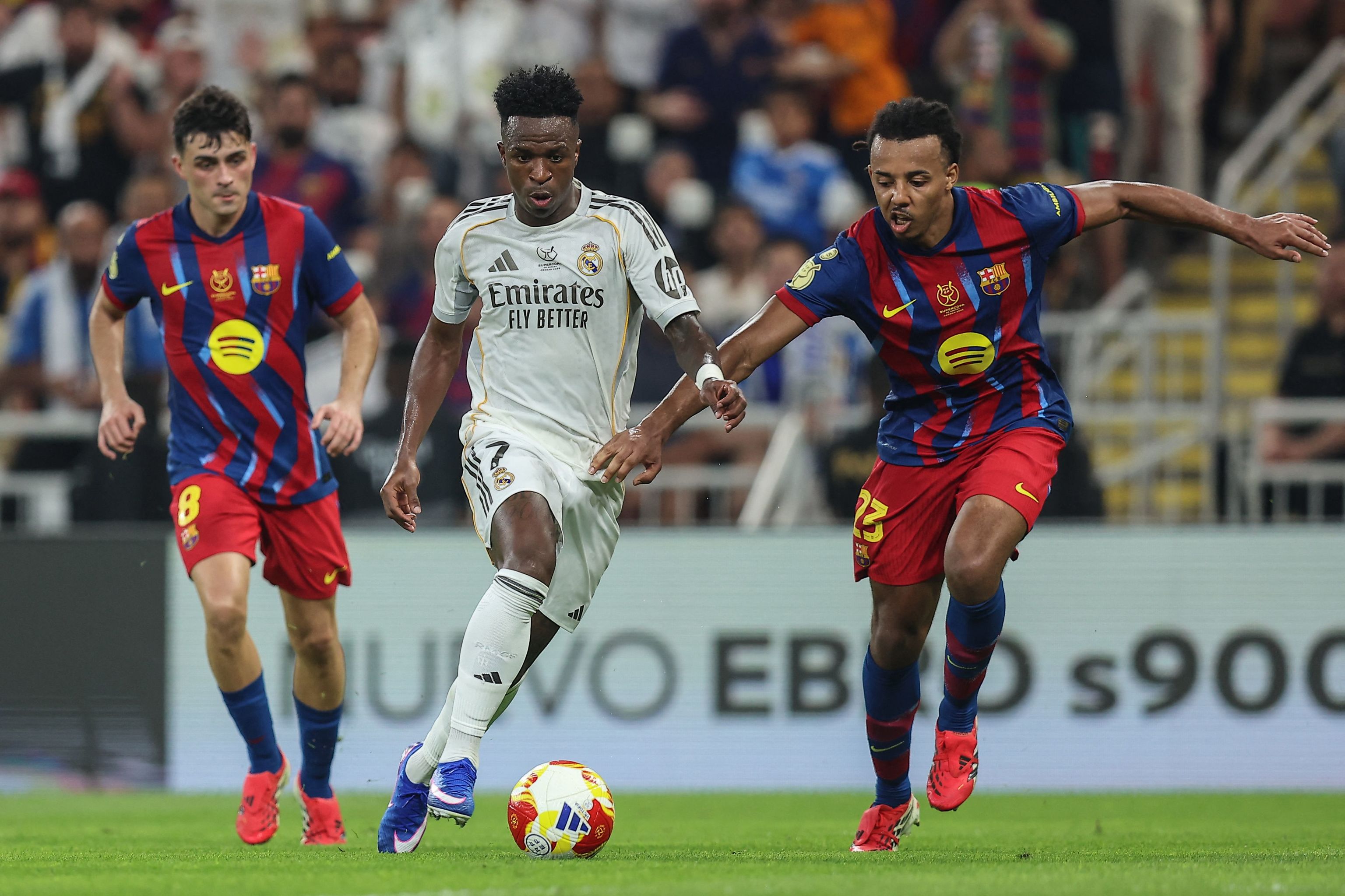 Vinicius conduce el balón ante Koundé y Pedri.