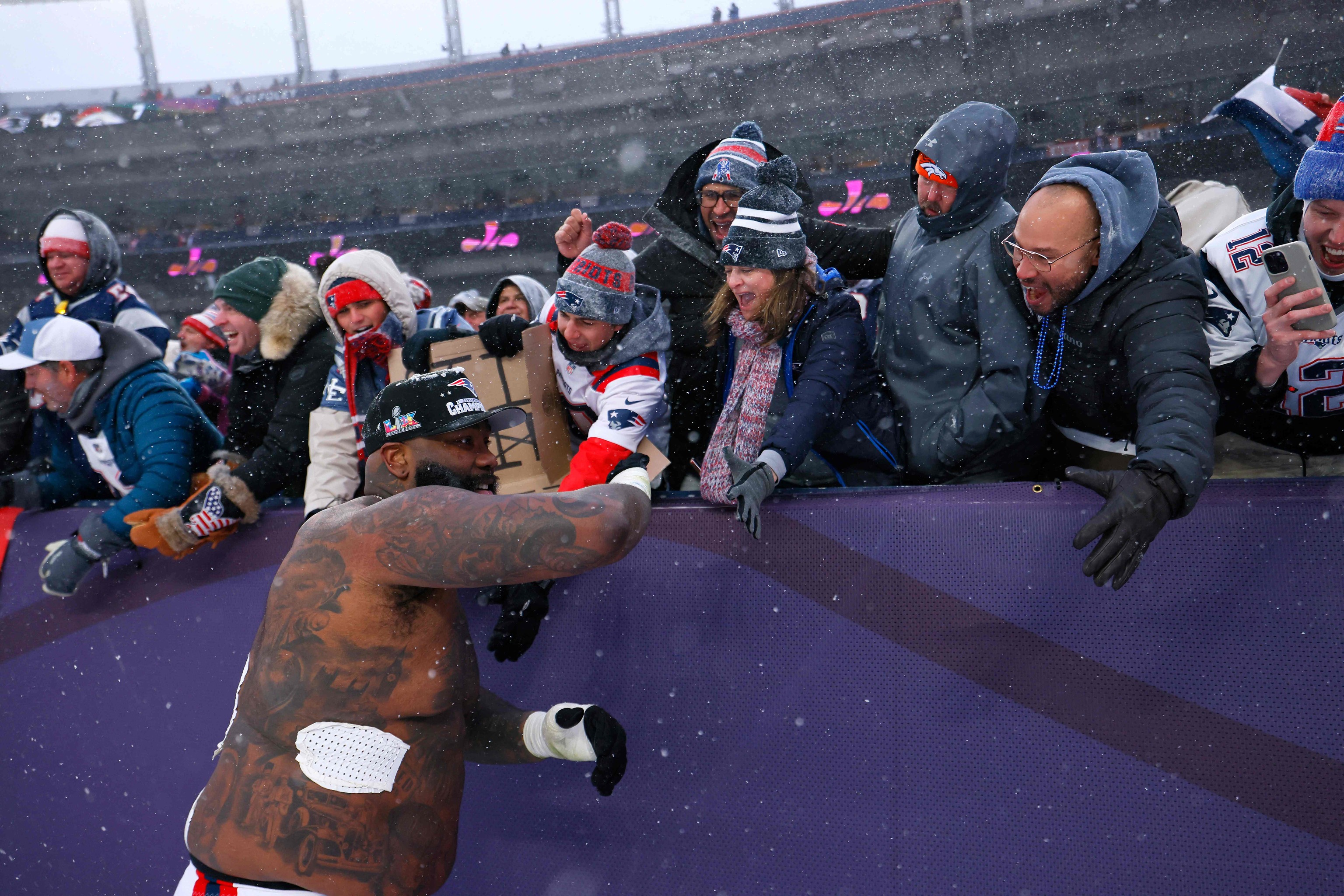 Morgan Moses #76 de los New England Patriots interactúa con los aficionados.