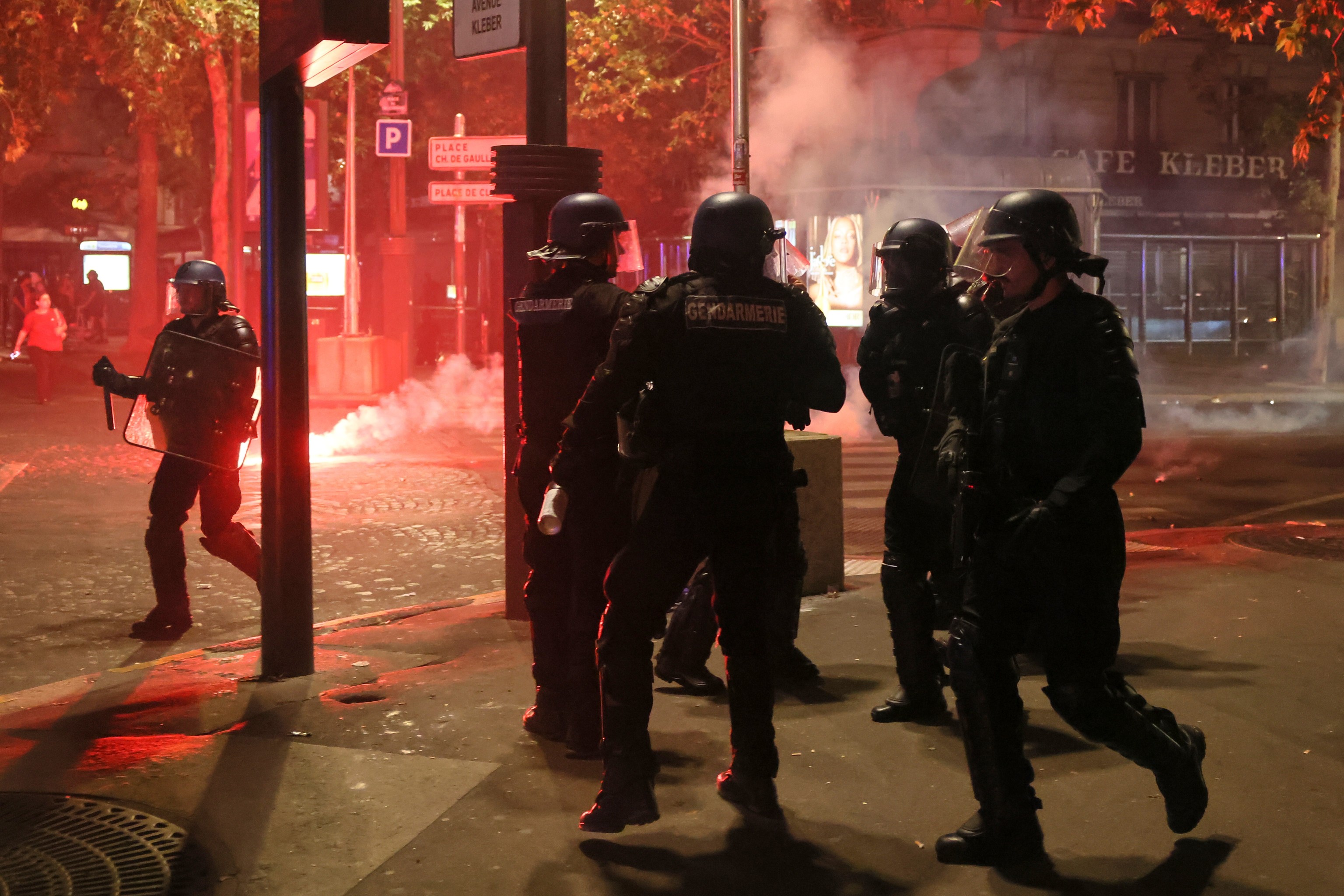 Policías intentan dispersar a aficionados del PSG, que encendieron bengalas para celebrar la victoria en las calles de París.